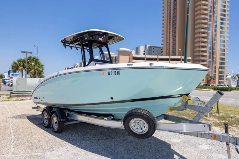 Slide: The Image of 2025 Yamaha Boats 255 FSH Sport E on trailer, urban background, sunny day. - 9