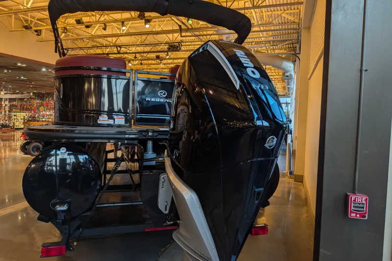 Slide: The Image of 2026 Regency 230 DL boat with powerful outboard motor displayed indoors. - 5