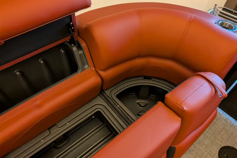 Slide: The Image of Luxurious seating with storage on 2026 Regency 230 DL boat, featuring rich brown upholstery. - 12