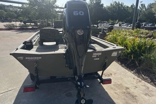Slide: The Image of 2026 Tracker Grizzly 1754 SC boat with 60 HP engine, parked outdoors. - 11