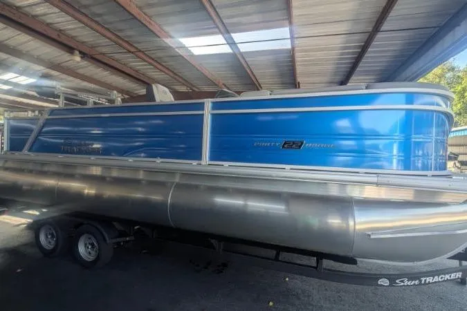 The Image of 2026 Sun Tracker Party Barge 22 RF XP3 pontoon boat in a covered storage area. - 0