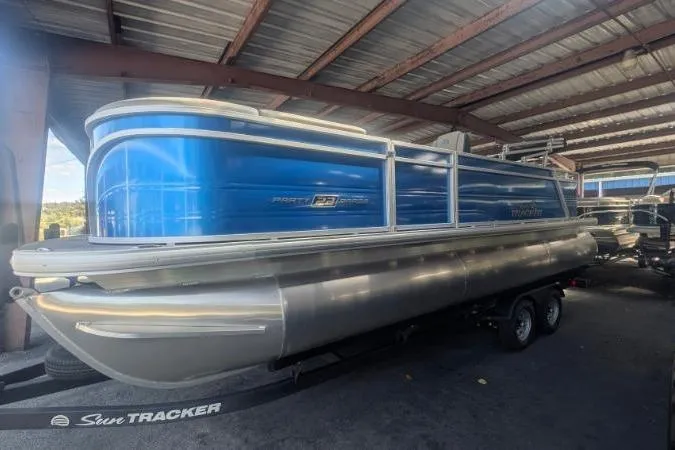 Slide: The Image of 2026 Sun Tracker Party Barge 22 RF XP3 pontoon boat in a covered storage area. - 5
