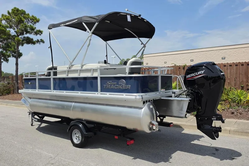 Slide: The Image of 2026 Sun Tracker Bass Buggy 18 DLX pontoon boat with Mercury outboard motor on trailer. - 14