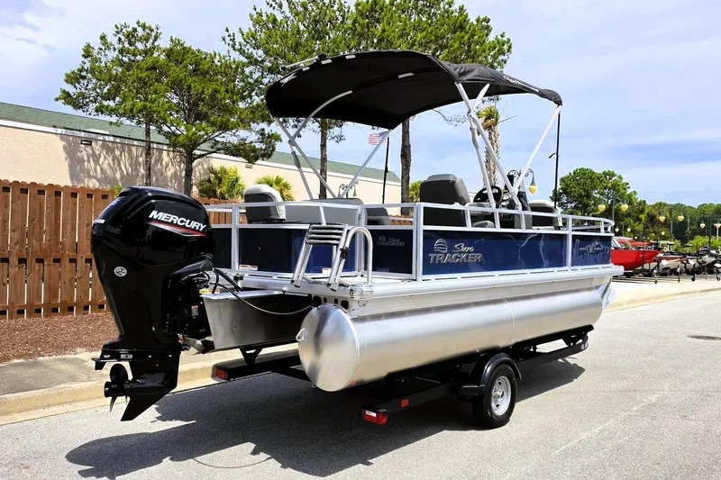 Slide: The Image of 2026 Sun Tracker Bass Buggy 18 DLX pontoon boat with Mercury outboard motor on trailer. - 3