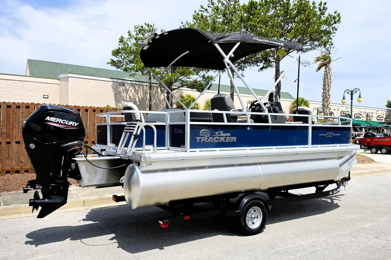 Slide: The Image of 2026 Sun Tracker Bass Buggy 18 DLX pontoon boat with Mercury outboard engine on trailer. - 2
