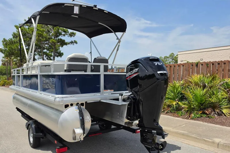 Slide: The Image of 2026 Sun Tracker Bass Buggy 18 DLX pontoon boat with Mercury 75 engine on trailer. - 15