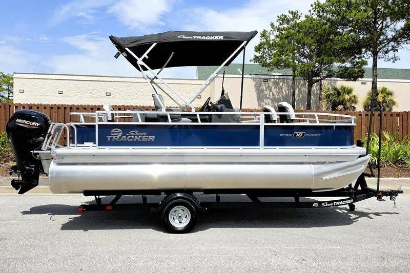 The Image of 2026 Sun Tracker Bass Buggy 18 DLX pontoon boat with Mercury outboard engine on trailer. - 0