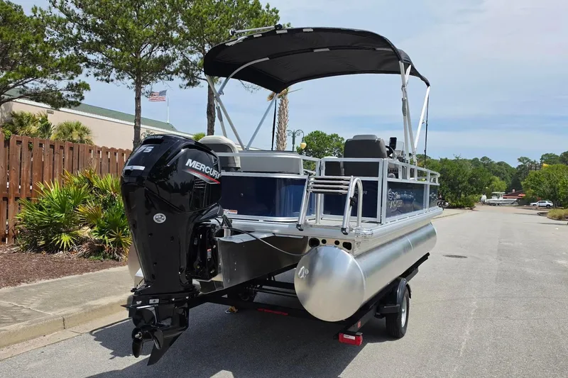 Slide: The Image of 2026 Sun Tracker Bass Buggy 18 DLX pontoon boat with Mercury outboard motor on trailer. - 5