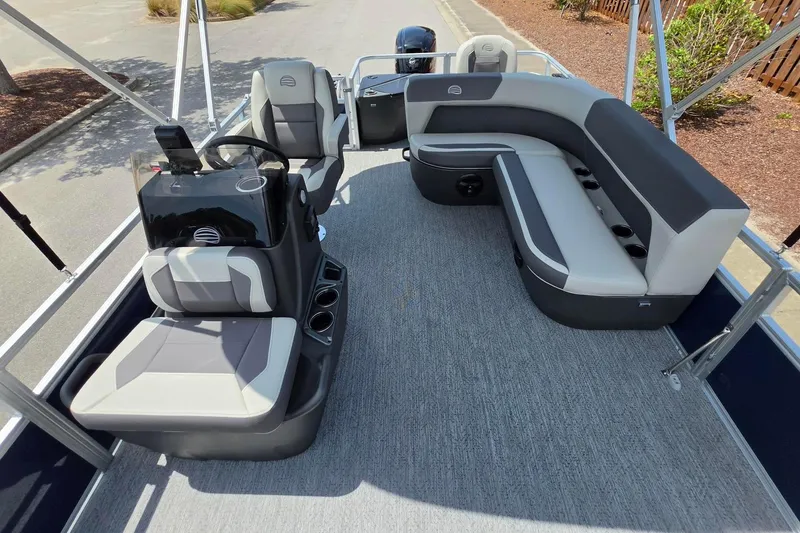 Slide: The Image of 2026 Sun Tracker Bass Buggy 18 DLX pontoon boat interior with seating and steering console. - 21