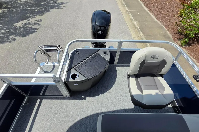 Slide: The Image of 2026 Sun Tracker Bass Buggy 18 DLX pontoon boat interior with seating and motor view. - 19