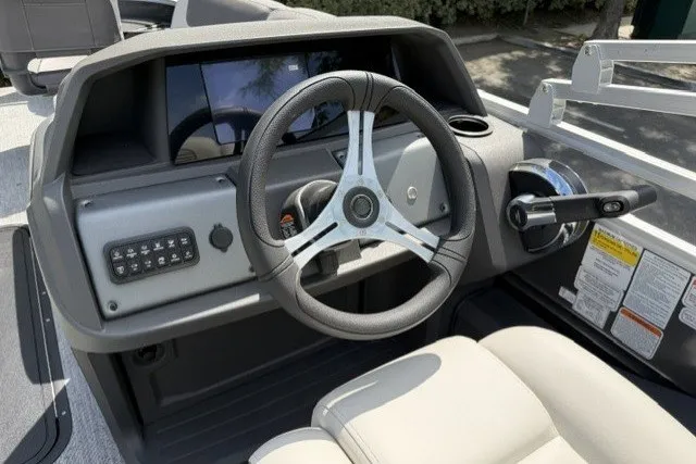 Slide: The Image of 2026 Sun Tracker Fishin' Barge 22 XP3 dashboard with steering wheel and controls. - 13
