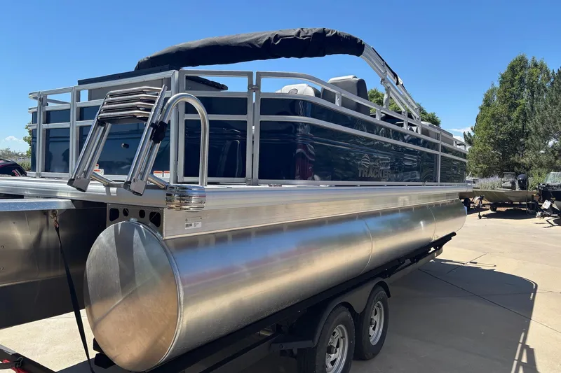 Slide: The Image of 2026 Sun Tracker Sportfish 24 XP3 pontoon boat on trailer, sunny day. - 3