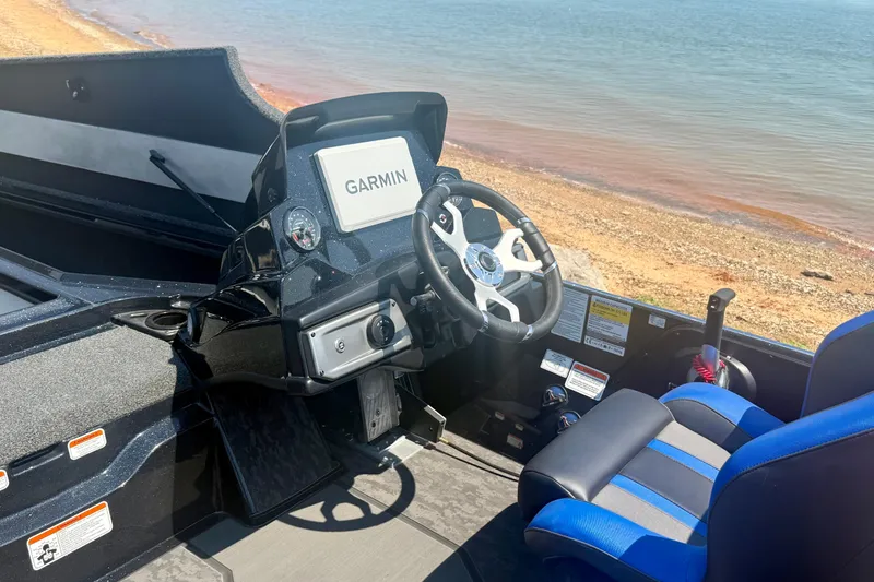 Slide: The Image of 2026 Nitro Z20 XL Pro boat cockpit with Garmin navigation, near a sandy shoreline. - 14