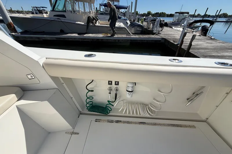 Slide: The Image of 1987 Phoenix 34 SFX Convertible boat interior with docked vessels in the background. - 14