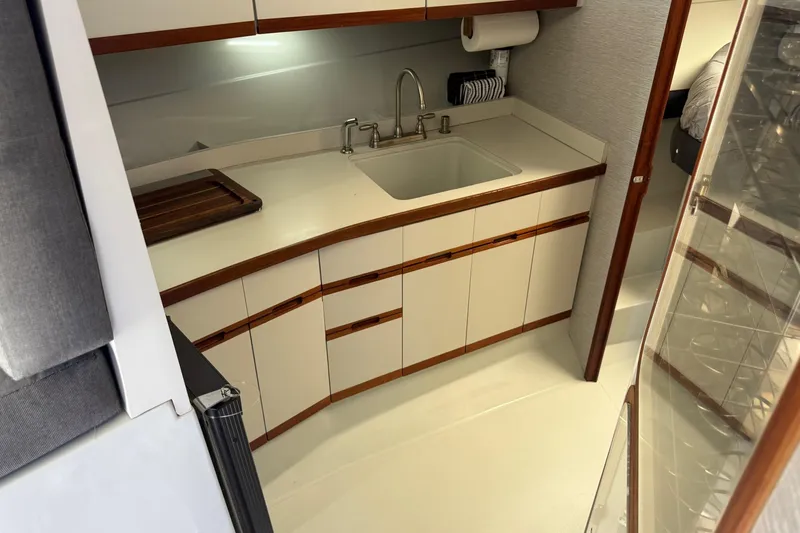 Slide: The Image of 1987 Phoenix 34 SFX Convertible yacht interior kitchen with sink and cabinetry. - 20