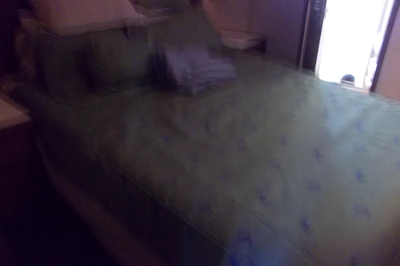 Slide: The Image of Cozy bedroom interior on 1982 Hatteras 46 Convertible yacht with green bedding. - 7