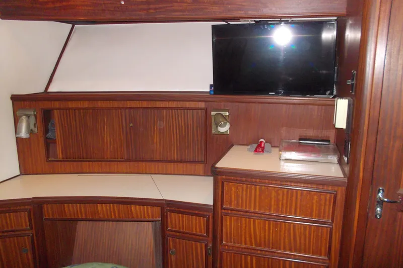 Slide: The Image of 1982 Hatteras 46 Convertible interior with wood cabinetry and mounted TV. - 8