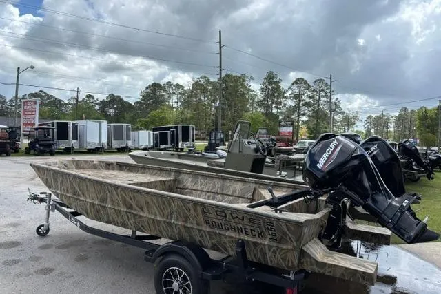 Slide: The Image of 2026 Lowe Roughneck 1660 Deluxe Tiller boat with Mercury engine on trailer, outdoors. - 7