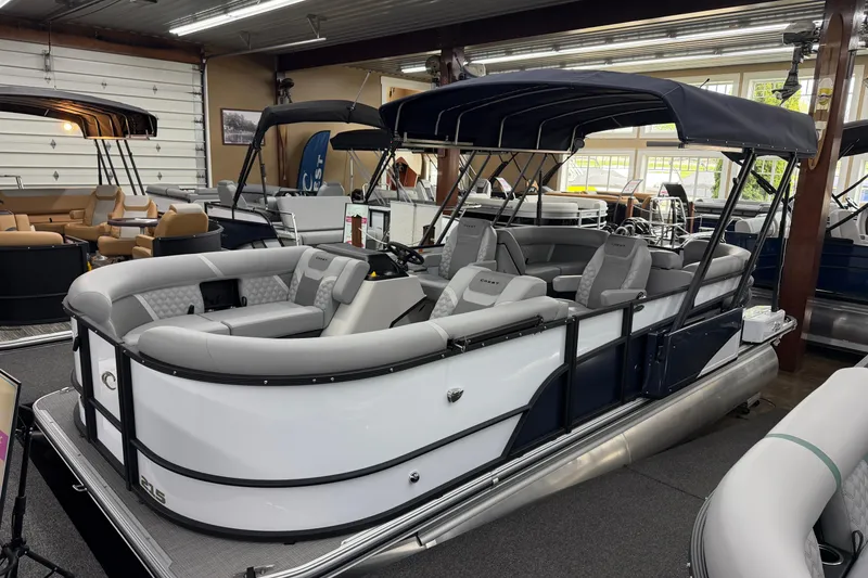 The Image of 2026 Crest Conquest 210 SLC pontoon boat with sleek design and comfortable seating in showroom. - 1