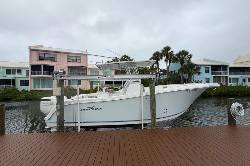 The Image of 2017 Pro-Line 29 Grand Sport boat docked near colorful waterfront homes. - 0