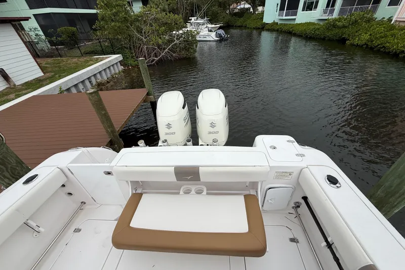 Slide: The Image of 2017 Pro-Line 29 Grand Sport boat with twin Suzuki 300 engines docked by a canal. - 15