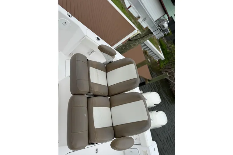 Slide: The Image of Brown and white seating on 2017 Pro-Line 29 Grand Sport boat docked by water. - 17