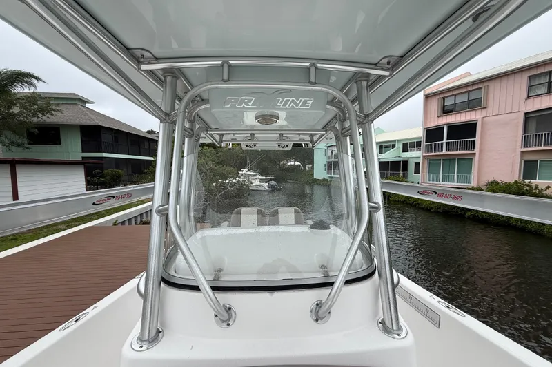 Slide: The Image of 2017 Pro-Line 29 Grand Sport boat docked near waterfront homes. - 22