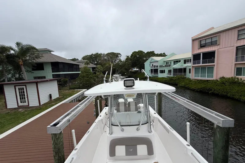 Slide: The Image of 2017 Pro-Line 29 Grand Sport boat docked near colorful waterfront homes. - 24