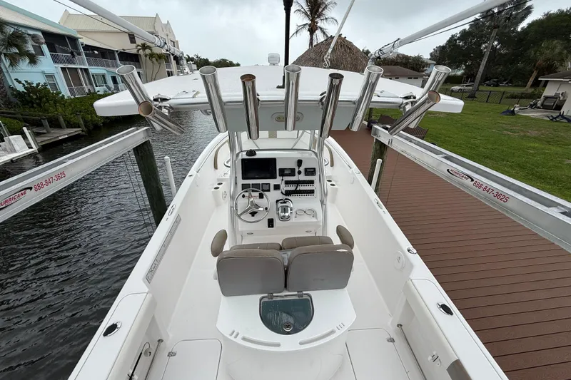 Slide: The Image of 2017 Pro-Line 29 Grand Sport boat with helm, rod holders, and seating, docked by waterfront homes. - 6