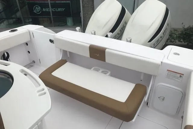 Slide: The Image of 2017 Pro-Line 29 Grand Sport boat interior with seating and dual Mercury engines. - 9