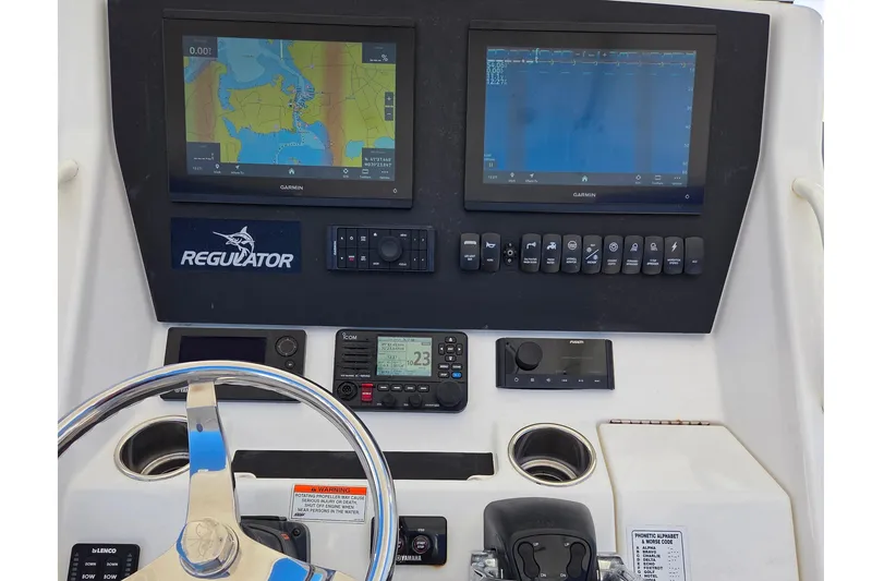 Slide: The Image of 2014 Regulator 25 boat dashboard with Garmin navigation displays and controls. - 11