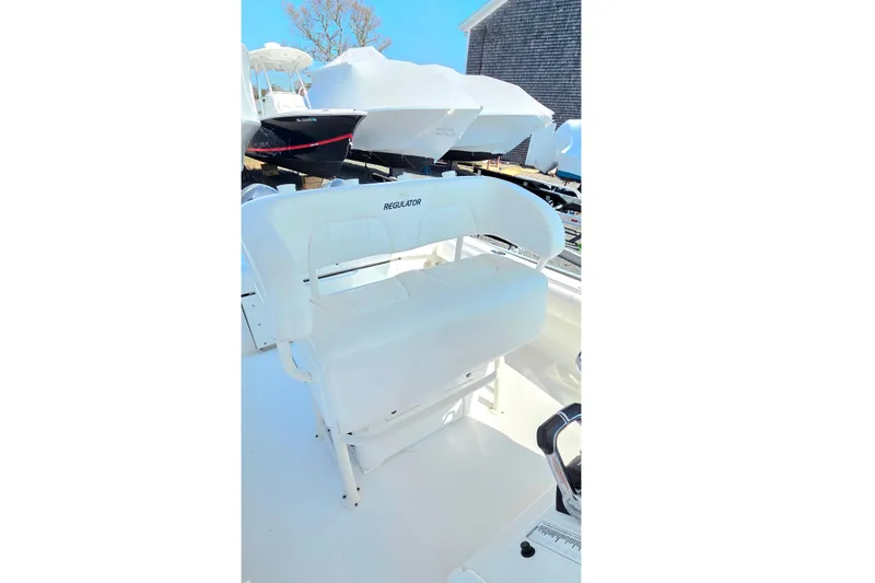 Slide: The Image of 2014 Regulator 25 boat with white seating, docked outdoors. - 12