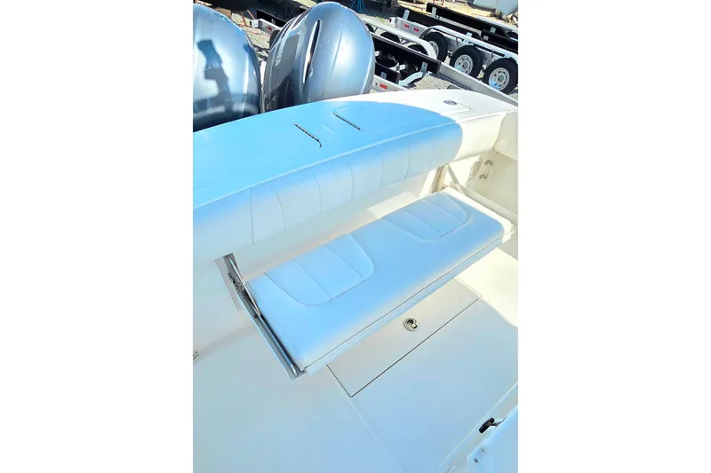 Slide: The Image of 2014 Regulator 25 boat with white cushioned seating and dual outboard motors. - 13
