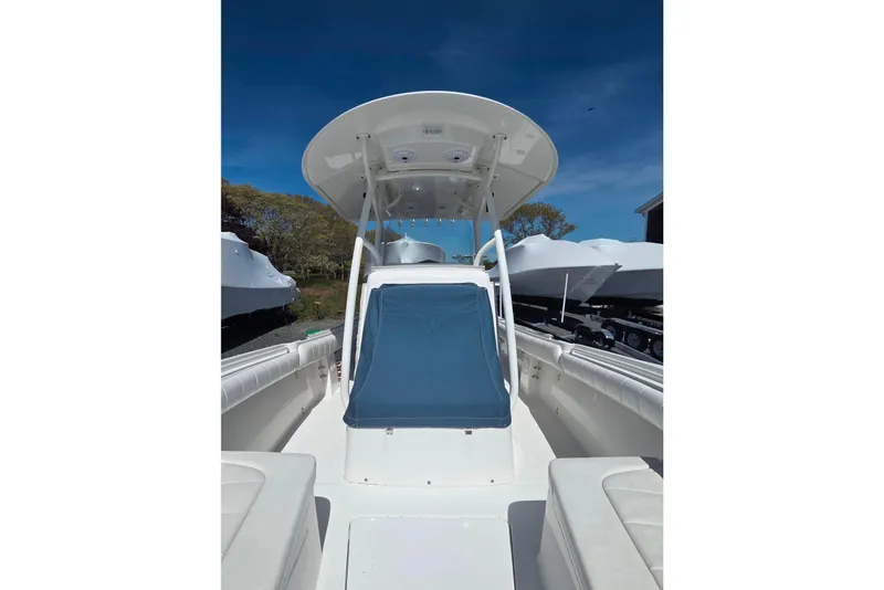 Slide: The Image of 2014 Regulator 25 boat with T-top and seating, docked under clear blue sky. - 16