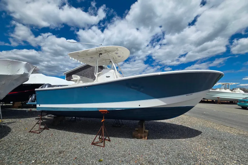 Slide: The Image of 2014 Regulator 25 boat on stands under a partly cloudy sky. - 3