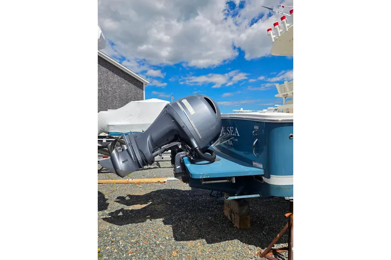 Slide: The Image of 2014 Regulator 25 boat with Yamaha outboard motor, parked outdoors under a blue sky. - 4