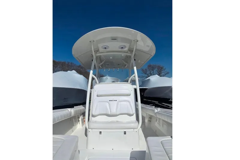 Slide: The Image of 2014 Regulator 25 boat interior with T-top under clear blue sky. - 7
