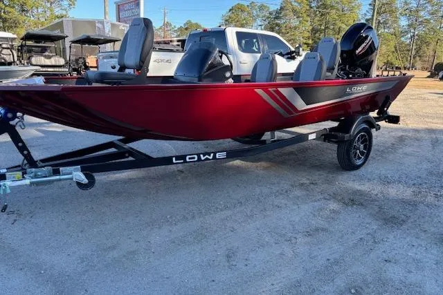 Slide: The Image of 2026 Lowe Skorpion 17 boat in vibrant red on a trailer, parked outdoors. - 5