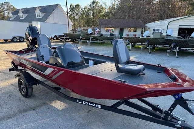 Slide: The Image of 2026 Lowe Skorpion 17 fishing boat in a showroom, featuring sleek red design and modern seating. - 8