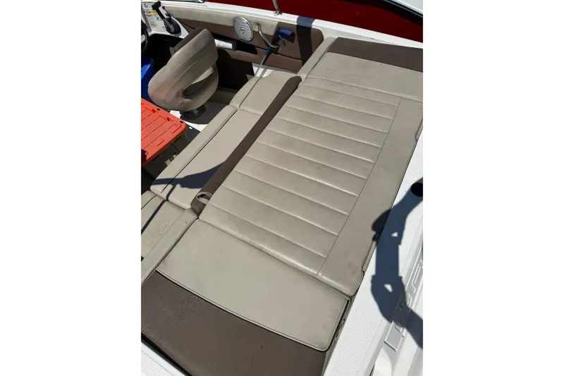 Slide: The Image of 2015 Bayliner 185 Bowrider interior with beige seating and steering area. - 10