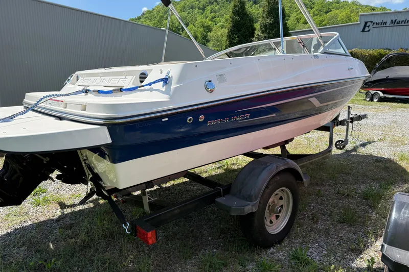 Slide: The Image of 2015 Bayliner 185 Bowrider on trailer, parked outdoors near a marine facility. - 3