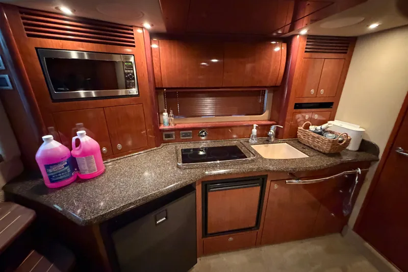 Slide: The Image of Luxurious 2006 Sea Ray 40 Sundancer yacht kitchen with wood cabinetry and modern appliances. - 14
