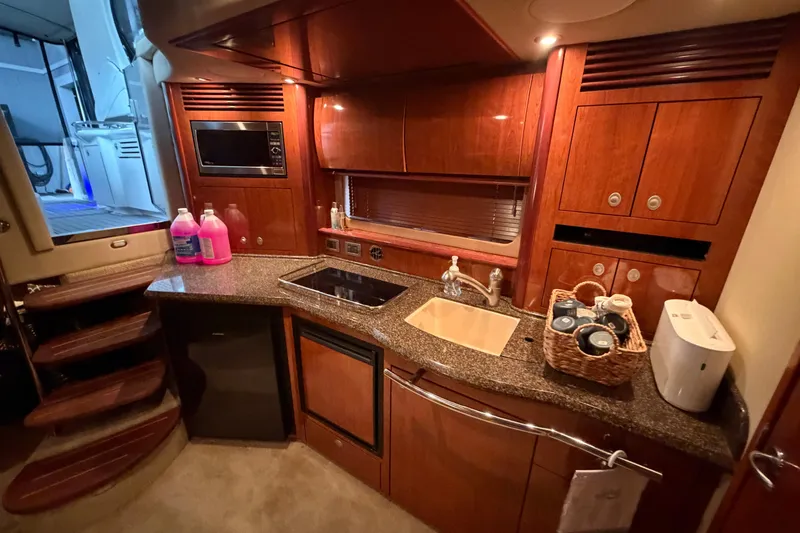 Slide: The Image of Luxurious 2006 Sea Ray 40 Sundancer yacht kitchen with wood cabinetry and modern appliances. - 24