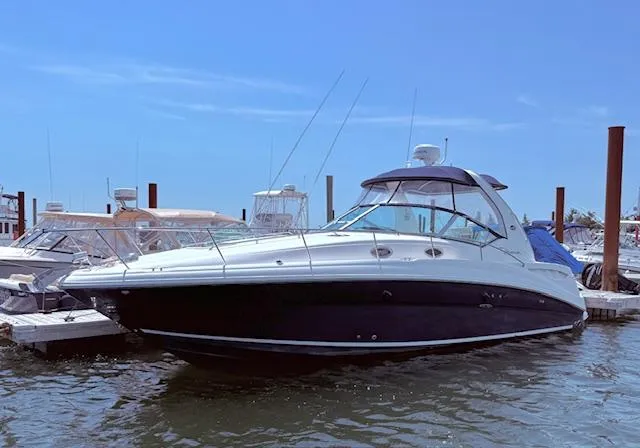 The Image of 2007 Sea Ray 320 Sundancer yacht docked at marina under clear blue sky. - 0