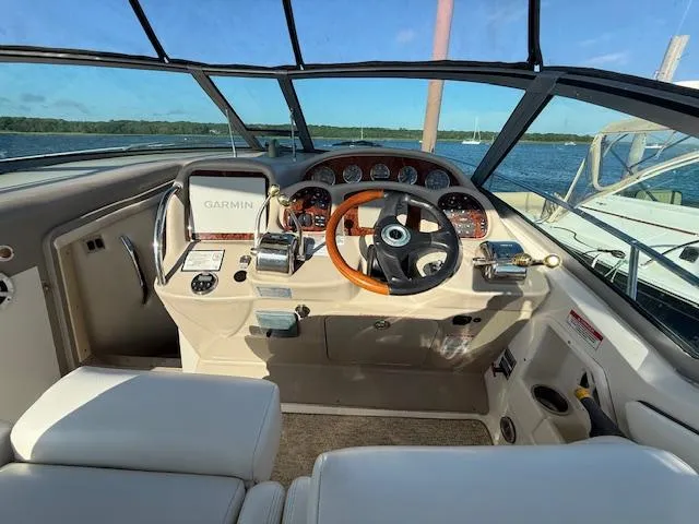 Slide: The Image of 2007 Sea Ray 320 Sundancer helm with Garmin navigation, overlooking serene waters. - 10