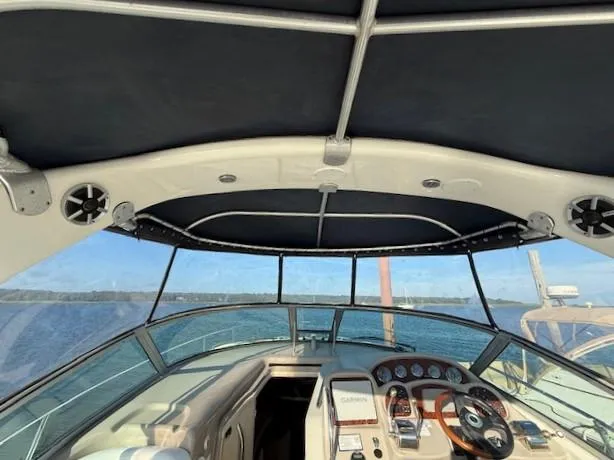 Slide: The Image of 2007 Sea Ray 320 Sundancer cockpit with canopy, steering wheel, and dashboard view. - 11