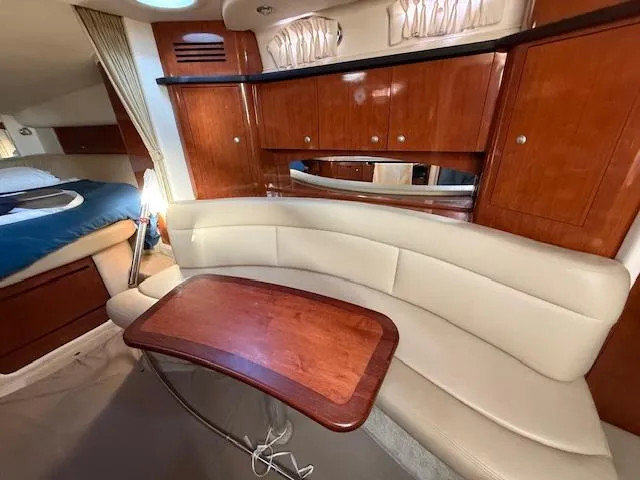 Slide: The Image of 2007 Sea Ray 320 Sundancer interior with curved seating and wooden table. - 15