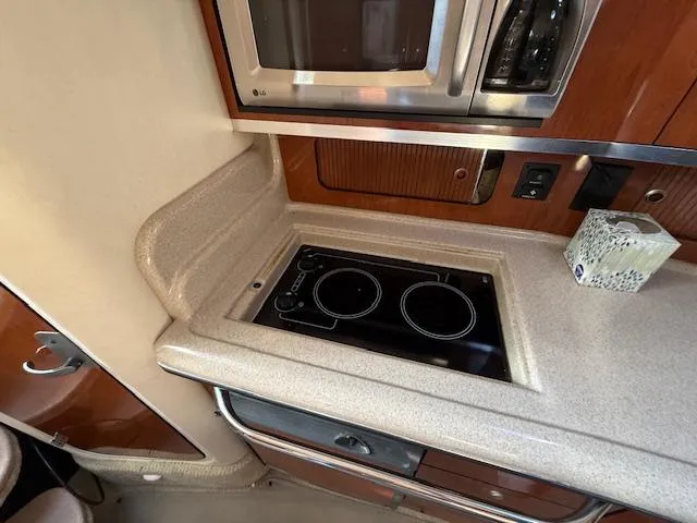 Slide: The Image of 2007 Sea Ray 320 Sundancer kitchen with stove, microwave, and countertop. - 19