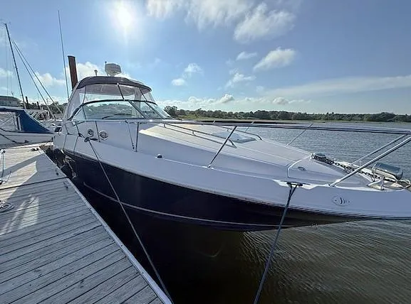 Slide: The Image of 2007 Sea Ray 320 Sundancer docked, showcasing sleek design and spacious deck under a clear sky. - 2