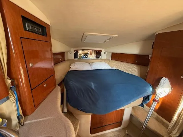 Slide: The Image of Cozy cabin interior of 2007 Sea Ray 320 Sundancer with bed and wooden cabinetry. - 20